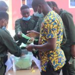 Staff acting as election officials to count ballots after close of polls, while the school cadet watch on as security