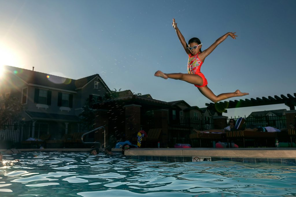 a girl jumps into water during swimming